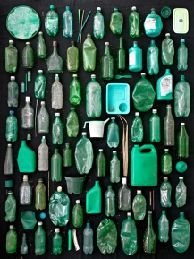 green plastic and glass containers on black background